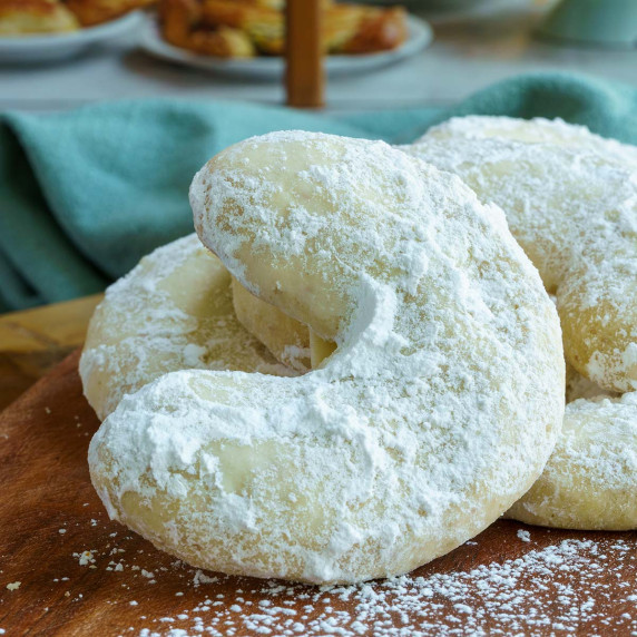 Almond crescent cookies in fromt of a bakery.