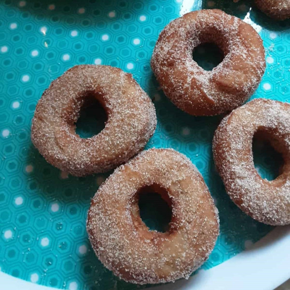 Four apple cider doughnuts on a tray.