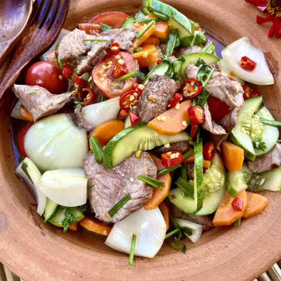 Thai beef salad with onions, carrots, and fresh herbs and spices.