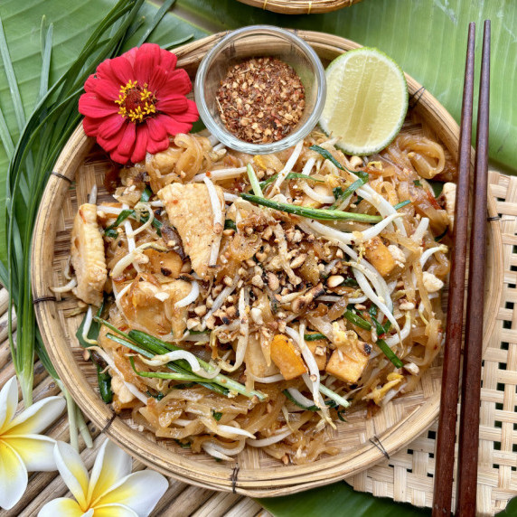 Authentic chicken pad Thai served with tofu, beand sprouts, lime wedge, and chili flakes.