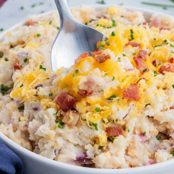 Loaded Bacon Mashed Potatoes RECIPE in a white bowl with a spoon.