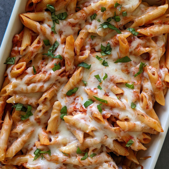 Cheesy baked penne pasta in a casserole dish
