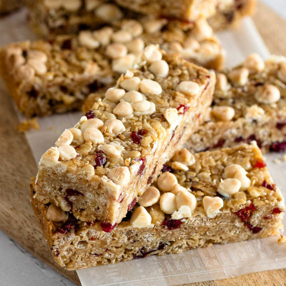 White chocolate cranberry granola bars arranged on a wooden board.