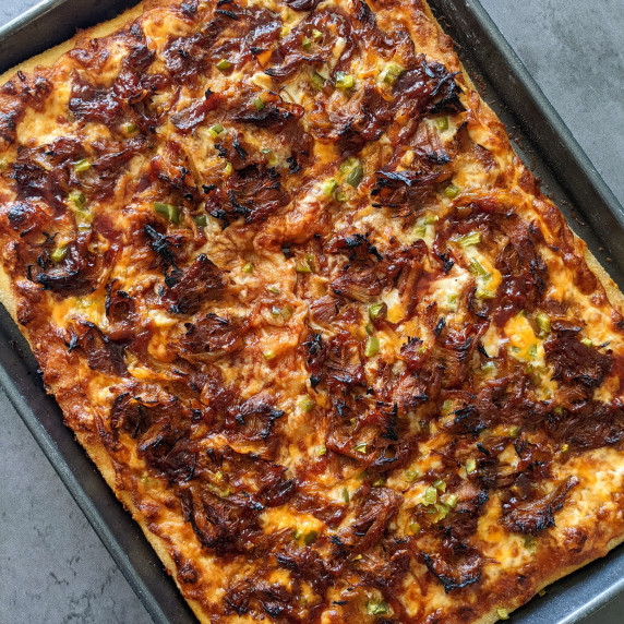 A sheet pan pizza topped with bbq pulled pork
