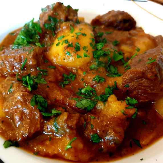 beef stew with potatoes and carrots in a serving plate