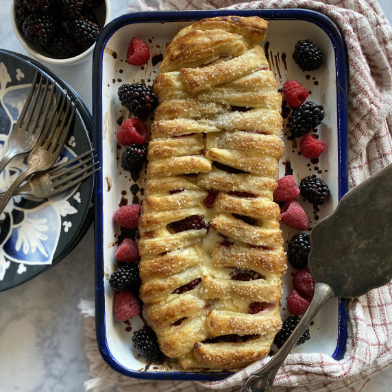 mixed berry danish on a tray with a plate and forks