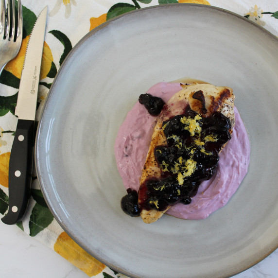 Seared chicken breast with blueberry lemon goat cheese spread, garnished with lemon zest