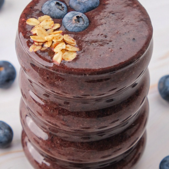 Blueberry smoothie without yogurt in a glass served with bllueberries and granola 