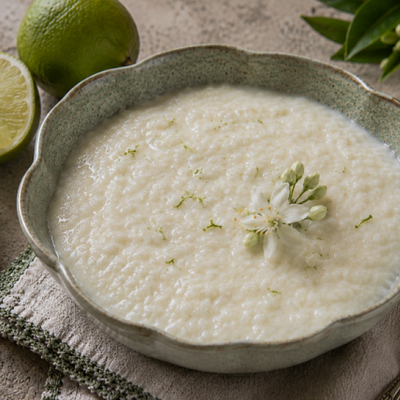 Buffalo milk rice pudding in a scalloped bowl with lime zest and citrus blossoms.