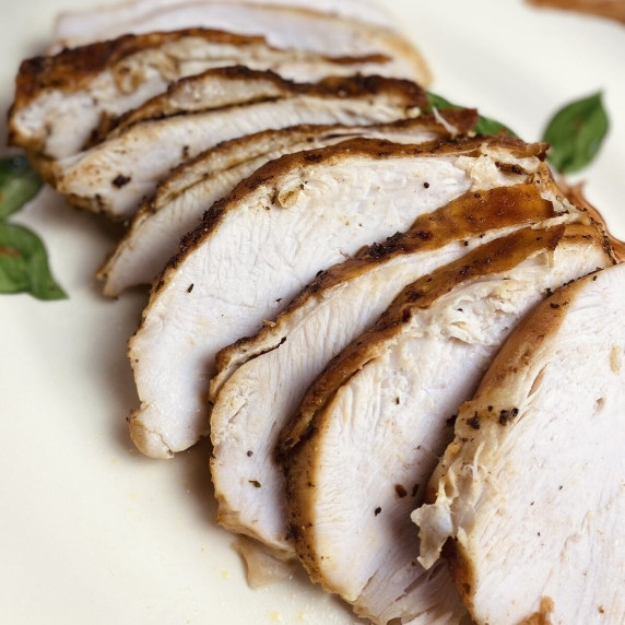 Several slices of roasted turkey breast fanned out on a platter.