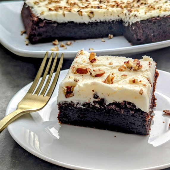 A piece of Canadian whisky brownies on a plate with a gold fork. 