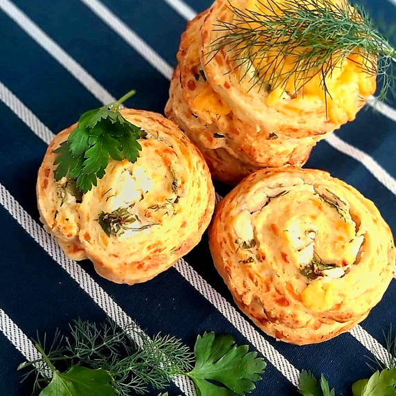 Overhead shot of stacks of pastry and yeast-free swirls/pinwheels with herbs on top.