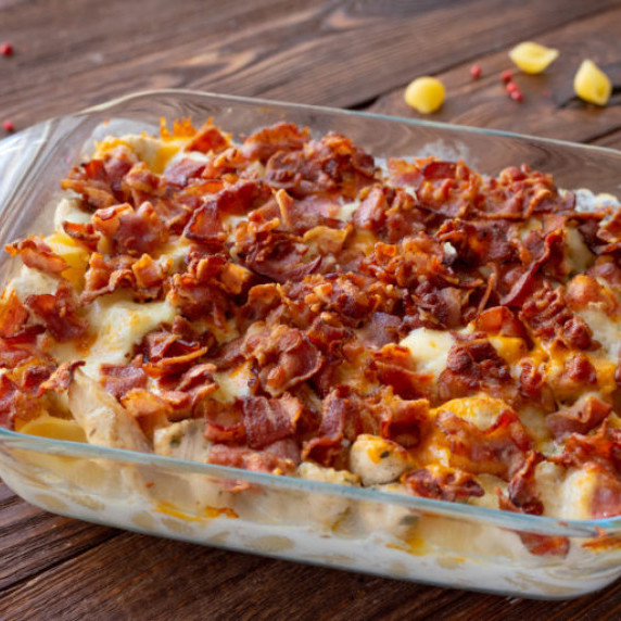 crumbled bacon on top of a cheesy chicken pasta casserole.