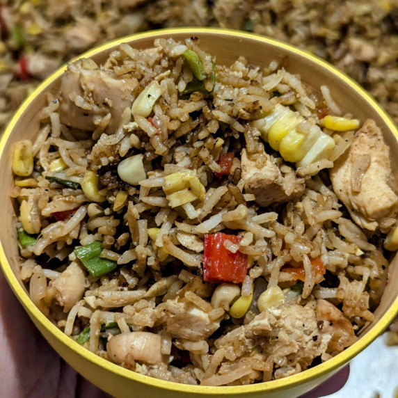 A bowl of chicken fried rice.