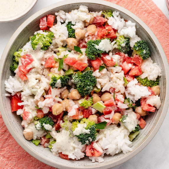 Chickpea rice salad in a bowl with broccoli and tomatoes.