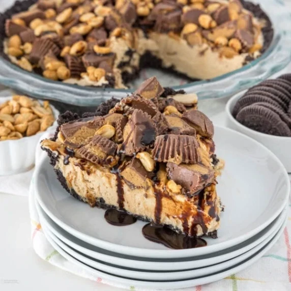 chocolate peanut butter pie with oreo crust, mini reeses cups, chocolate drizzle, and peanuts 