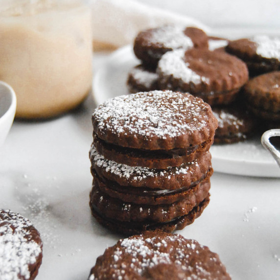 stack of mudslide sandwich cookies on marble background with powdered sugar 