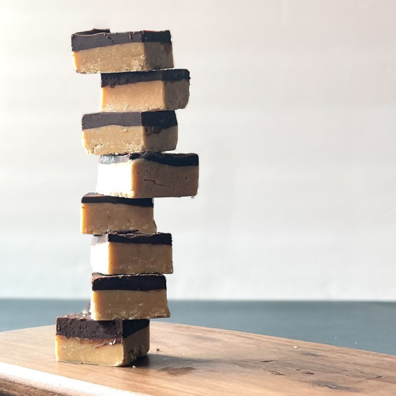 eight squares of peanut butter chocolate fudge stacked in a tower.