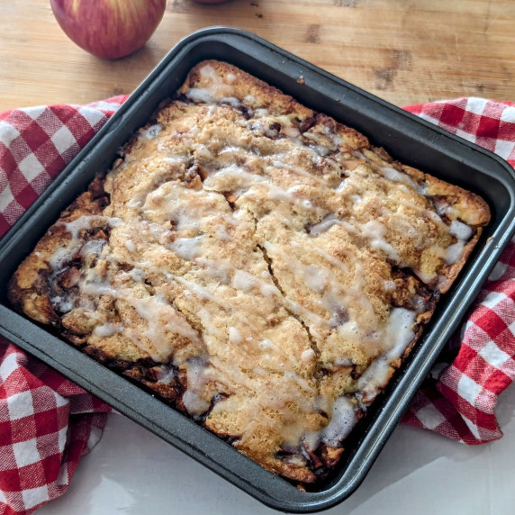 A pan of Apple Cinnamon Cake on a red and white checkered towel.