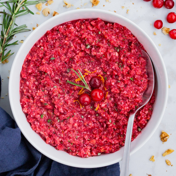 Fresh Cranberry Orange Relish RECIPE served in a white bowl and with a spoon.