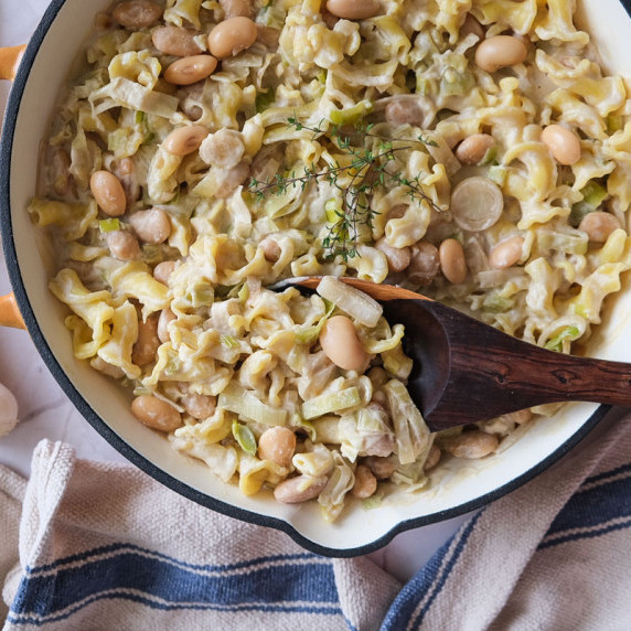 Close up of creamy leek and butter beans pasta in a pan 