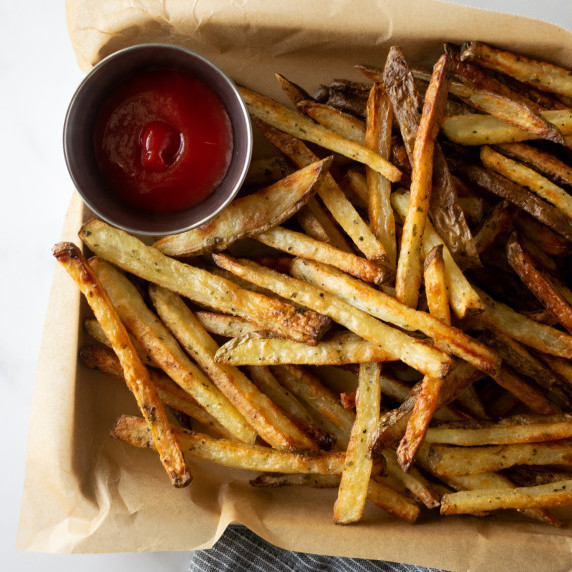 crispy fries on a baking sheet with ketchup.