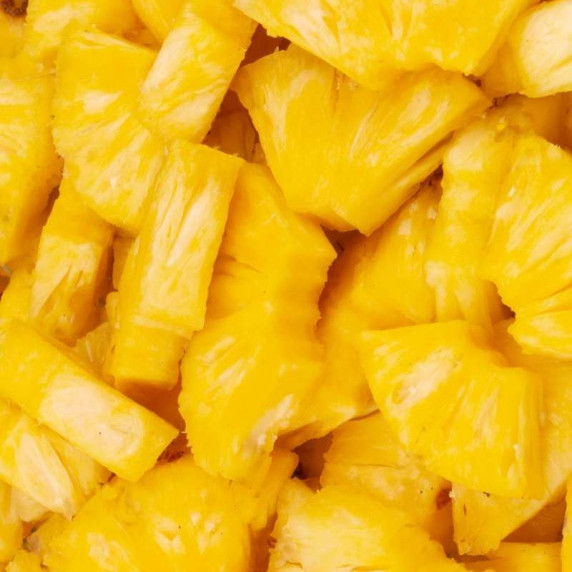 Close view of a pile of cut fresh pineapple pieces.