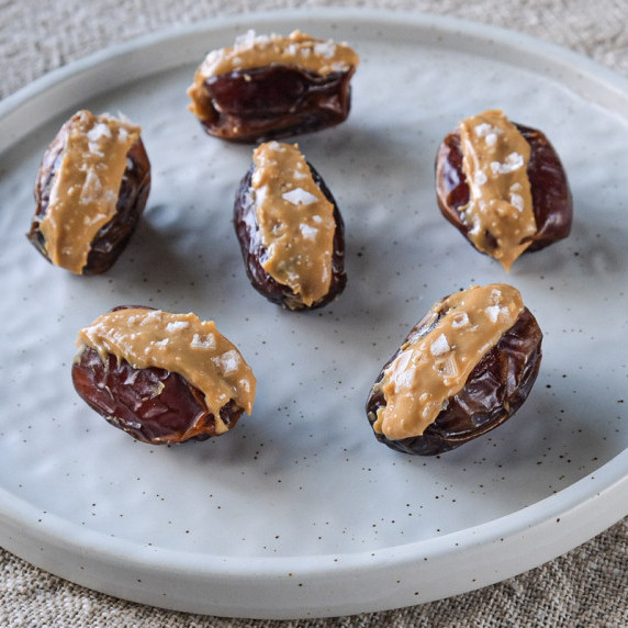 Dates stuffed with peanut butter served on a plate