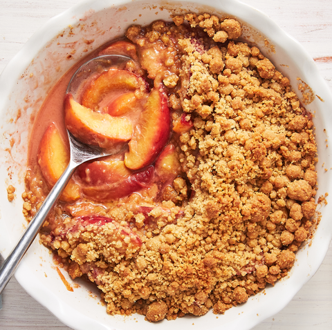 Peach crumble in a white plate with a spoon