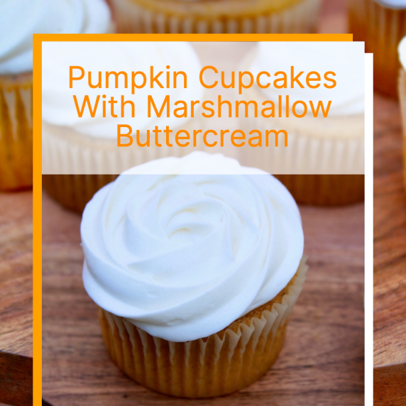 Pumpkin Cupcakes with marshmallow buttercream icing swirled on top on a brown pate outside.  