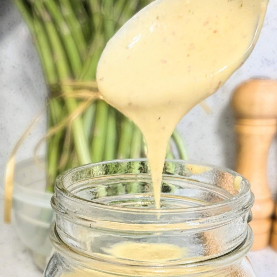 homemade immersion blender Caesar salad dressing being dripped off a spoon into a jar