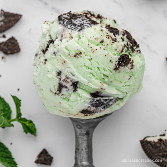 metal ice cream scoop with mint cookie ice cream ball on top.