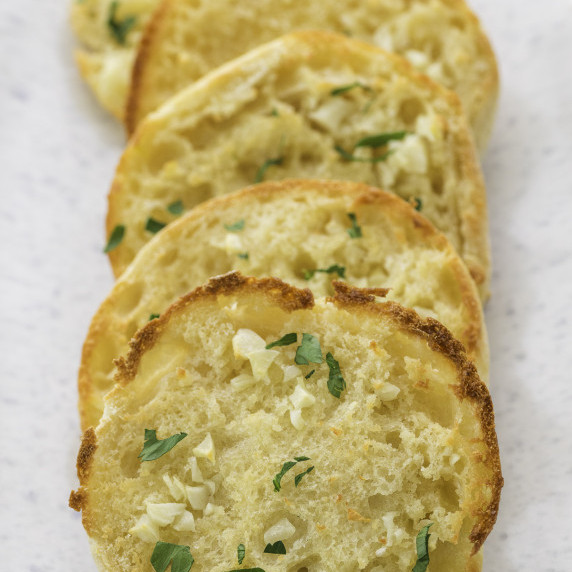 english muffin garlic bread half on a baking sheet
