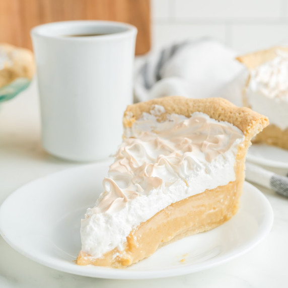 A white plate with a slice of butterscotch meringue pie.