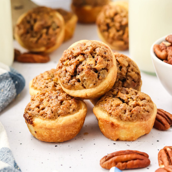 A stack of pecan tassies on a marble board.