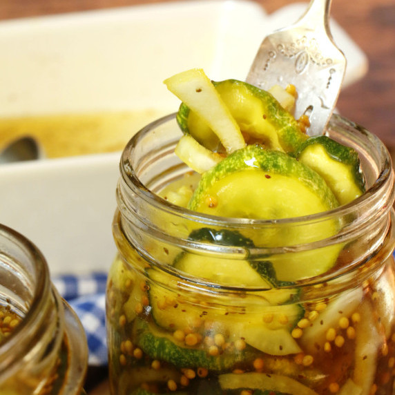 A jar of bread and butter pickles with a fork.