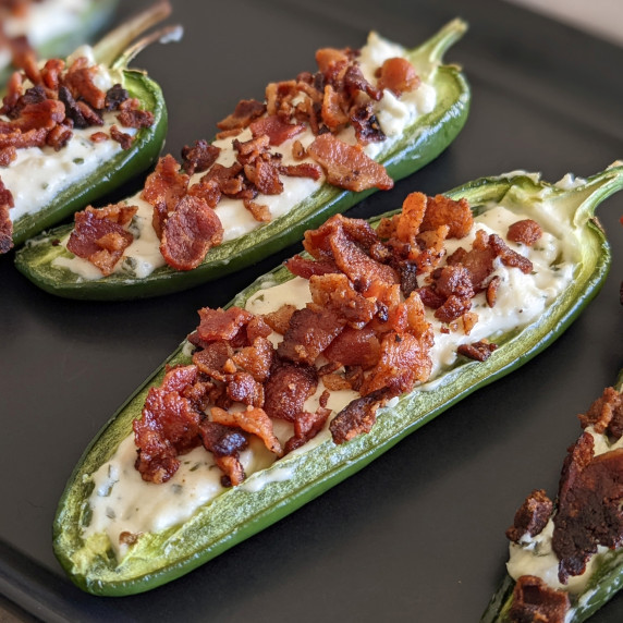 A jalapeno popper topped with crispy crumbled bacon