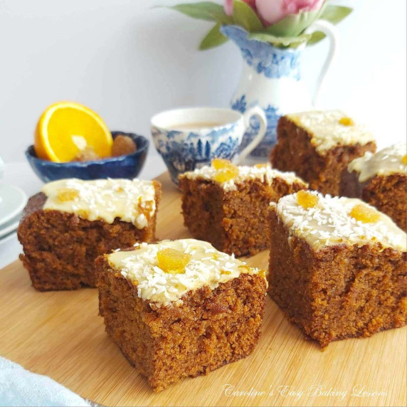Close shot of several cake squares of gingerbread with orange glaze.
