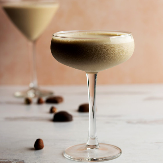 Godiva chocolate martini in a glass with hazelnuts and chocolate scattered around