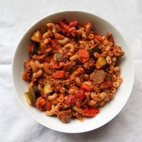 Bowl of low FODMAP goulash on a white background