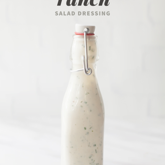 A flip-top glass bottle of homemade greek yogurt ranch dressing on a white background.