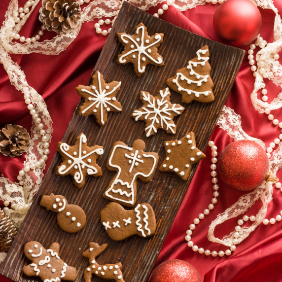 greek style gingerbread cookies on a wooden platter surrounded by christmas decorateions