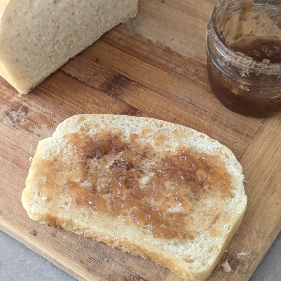 A slice of homemade bread with apple jam. 