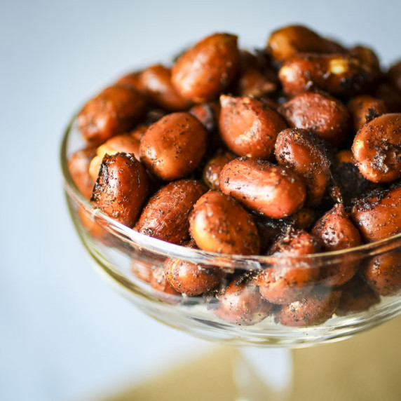 Close up shot of chipotle peanuts in a clear martini glass.