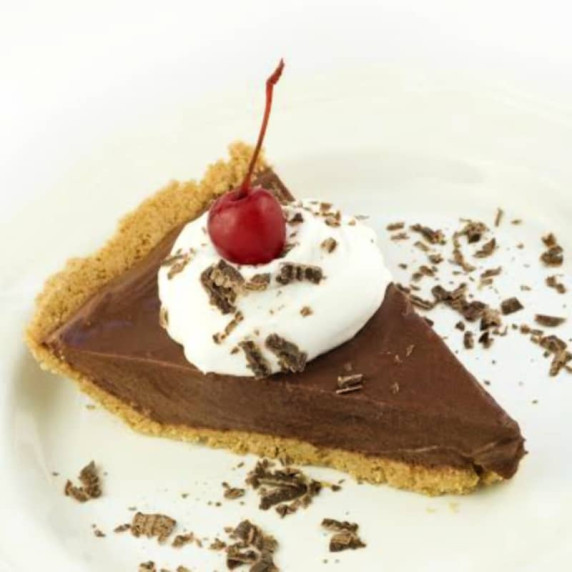 slice of classic chocolate pudding pie with whipped cream and cherry
