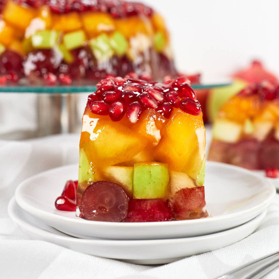 Slice of jello fruit cake with colorful layers.