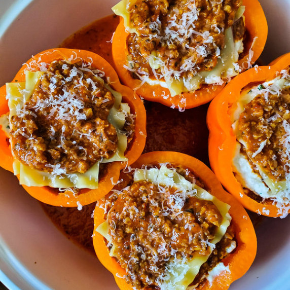 Gorgeous orange bell peppers stuffed with lasagna and topped with bolognese.
