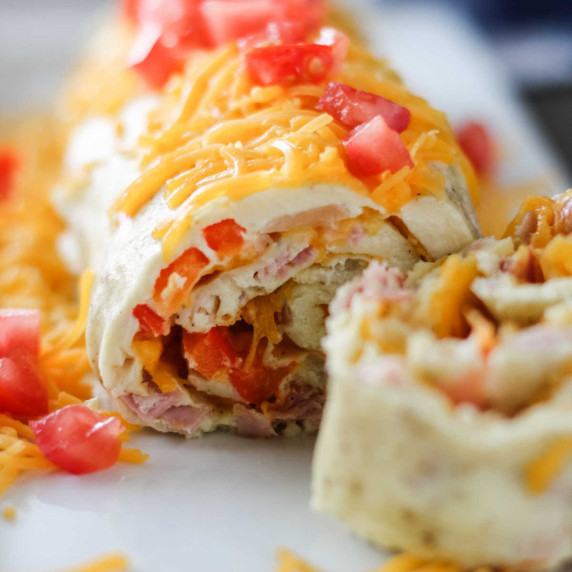 Scrambled eggs with ham, peppers and onions wrapped around cheesy filling and cut into slices.