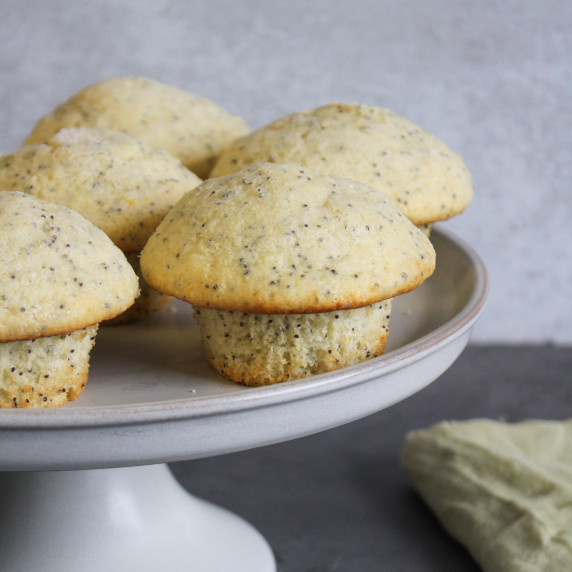 Lemon poppy seed muffins on a cake stand.