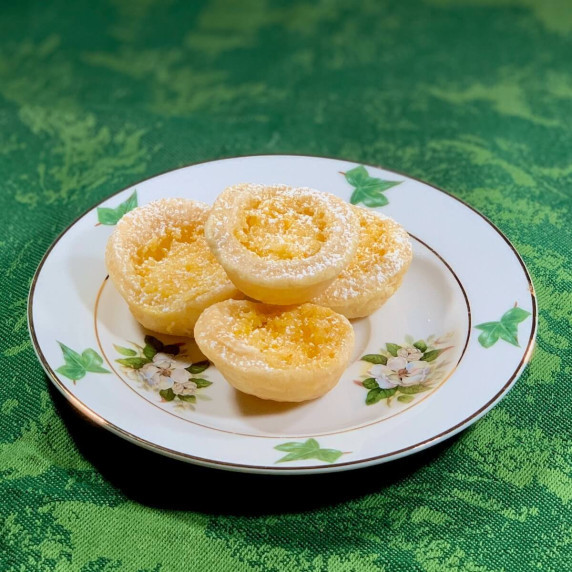 mini lemon tartlets plated closeup on green background